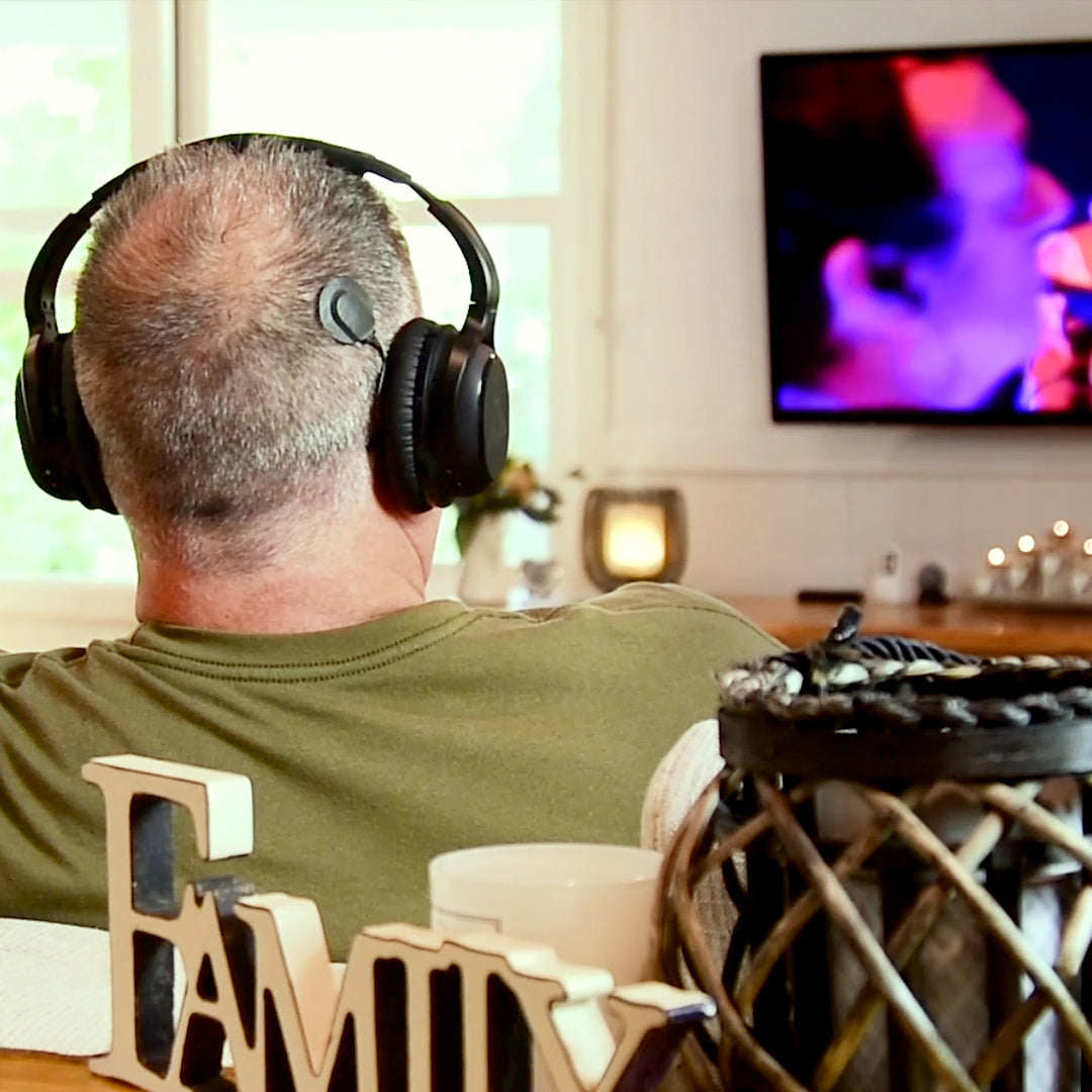 John Ross watching TV with Audeara headphones
