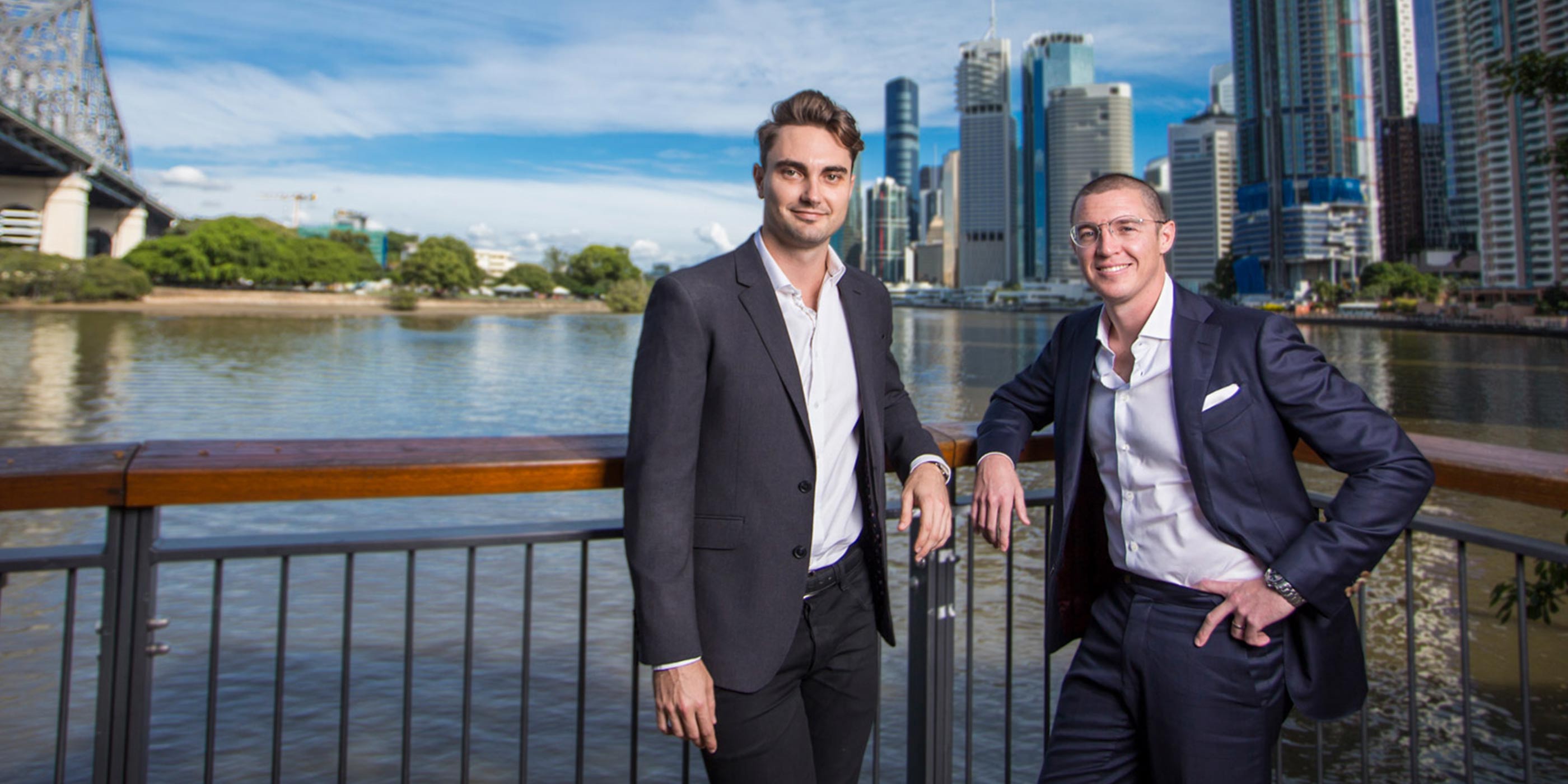 Audeara founders, Alex Afflick and Dr. James Fielding standing together with the Brisbane River and cityscape in the background