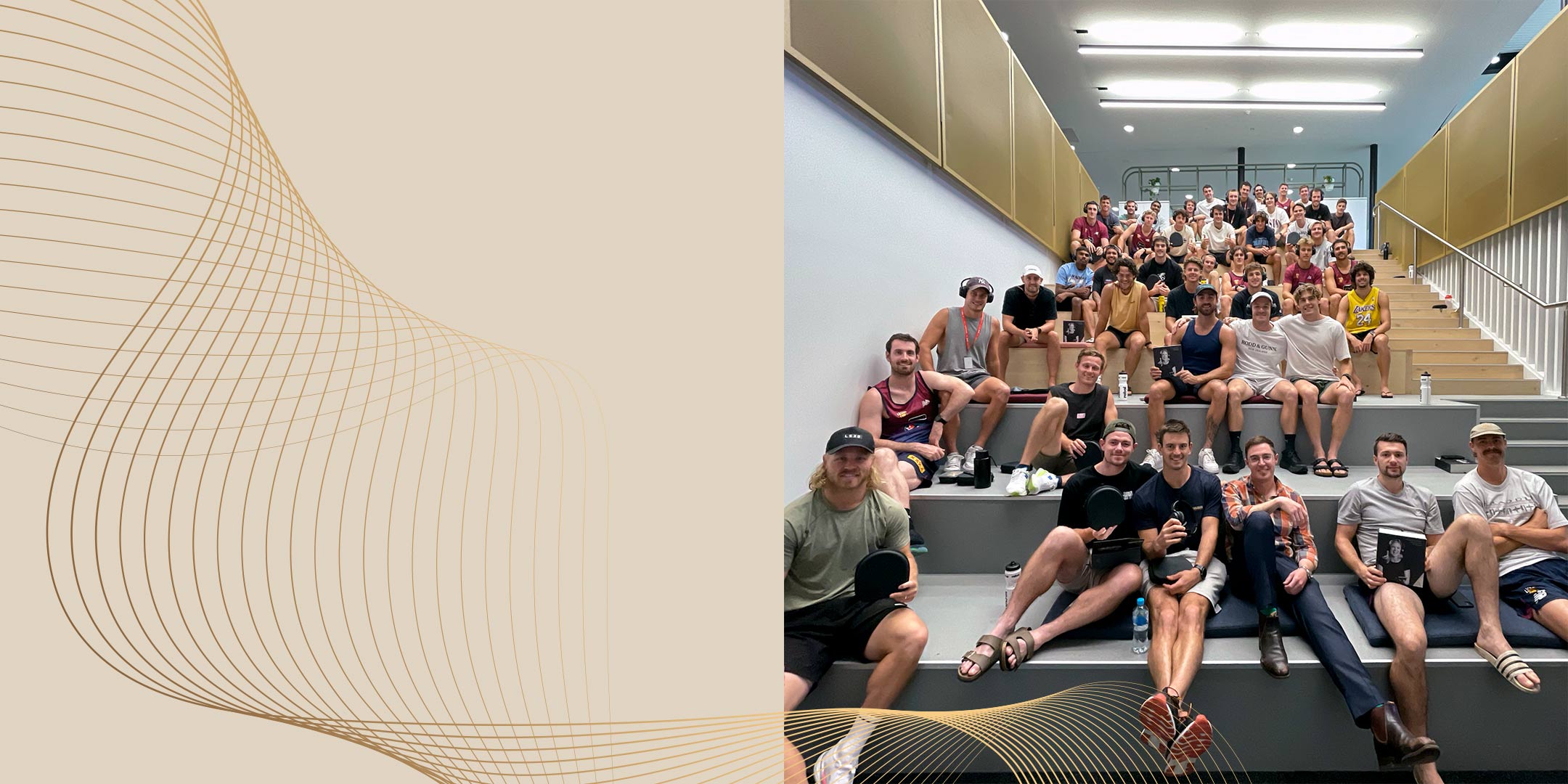 Audeara CEO Dr James Fielding, sitting with the Brisbane Lions AFL team who are posing with their Audeara headphones