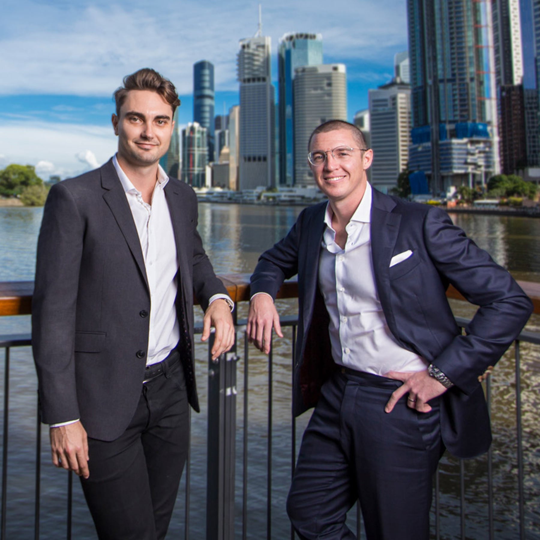 Audeara founders, Alex Afflick and Dr. James Fielding standing together with the Brisbane River and cityscape in the background